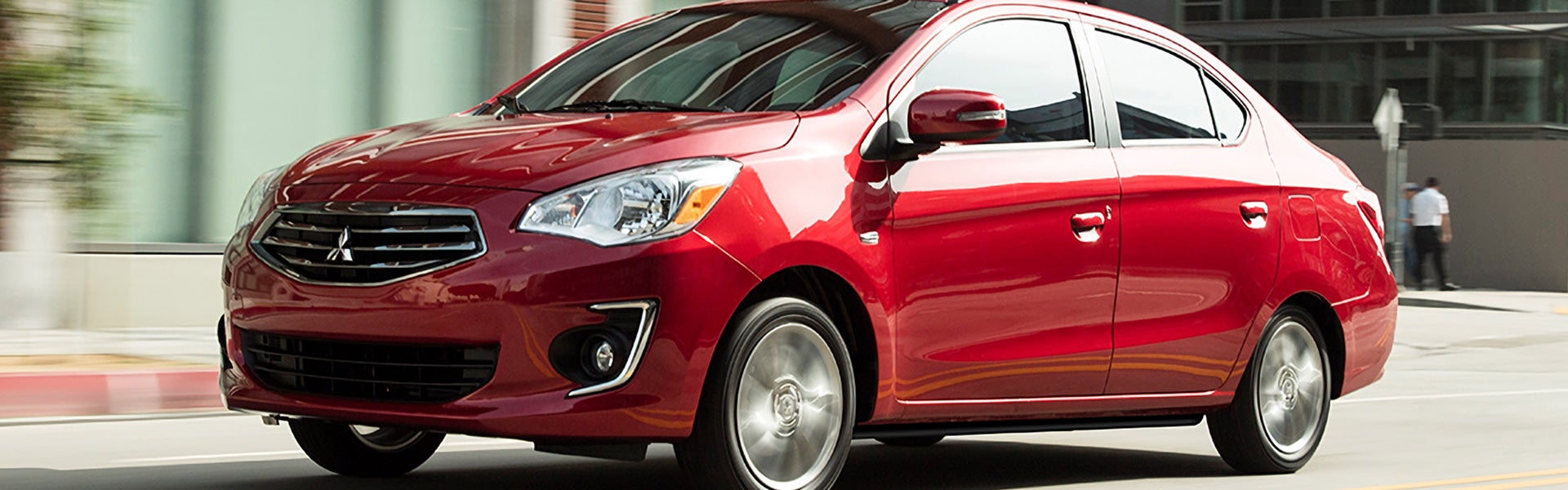 A Red Mitsubishi Mirage-G4 running on road left side view