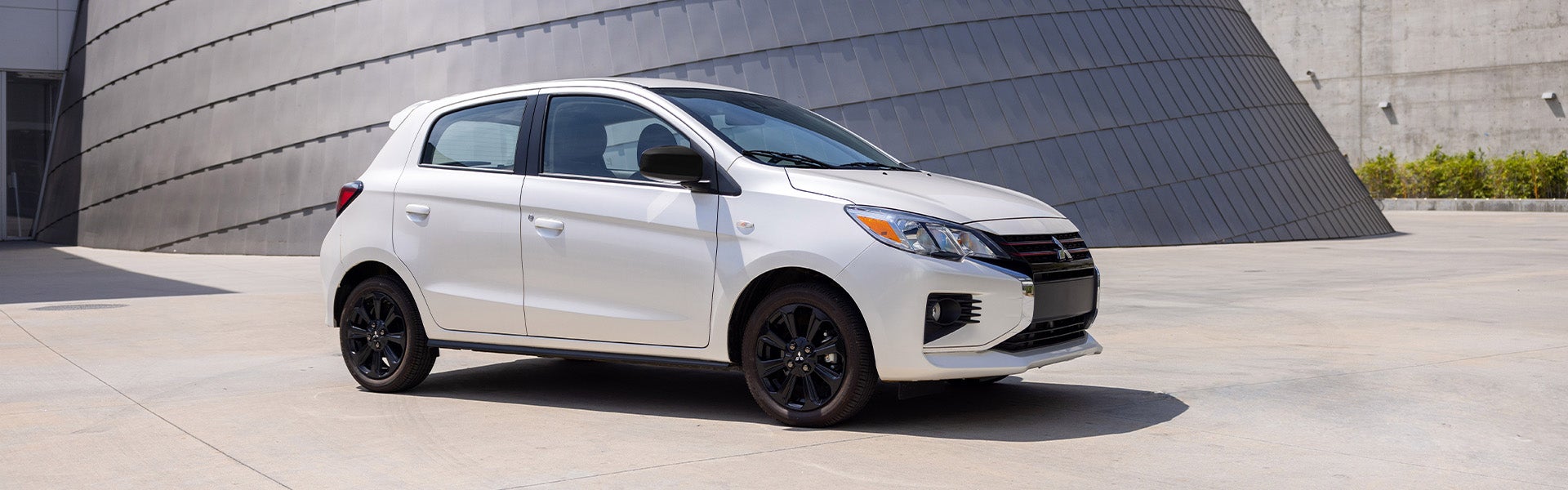 A white Mirage Car parked front of building