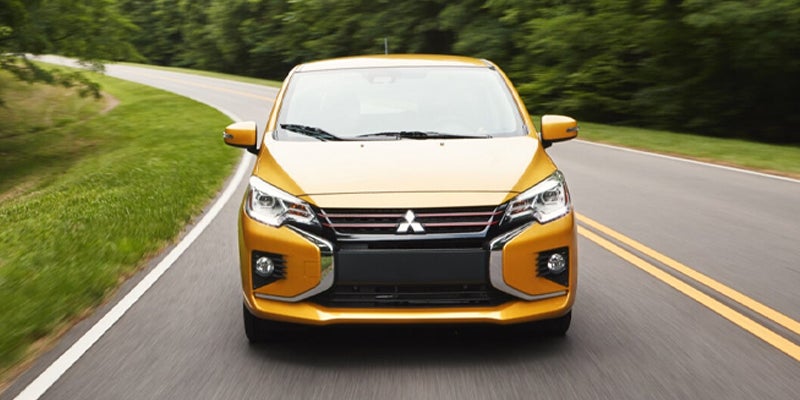 A Yellow Mirage Car running on road in center of grass or jungle